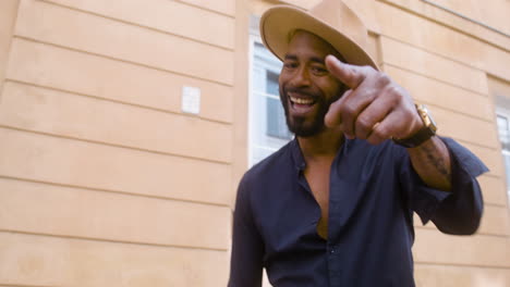 uomo afro-caraibico sorridente con cappello panama che balla salsa da solo in strada 3