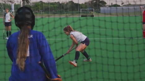 female hockey players playing on the field