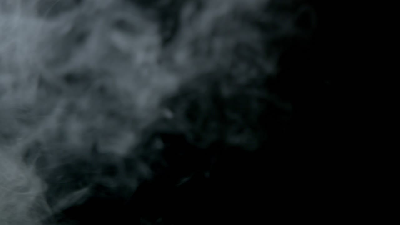 Vapore di fumo su sfondo nero che attraversa l'inquadratura