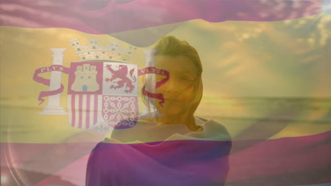 animation of flag of spain over happy senior caucasian woman on beach