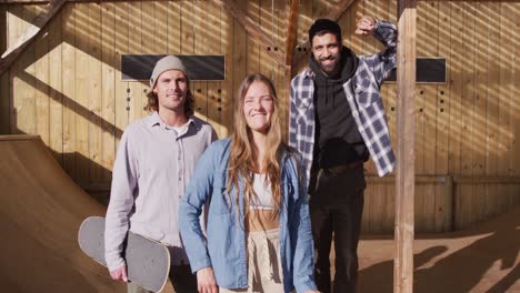 video of happy diverse female and male skateboarders in skate park