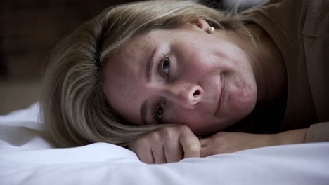 una mujer joven acostada en la cama.