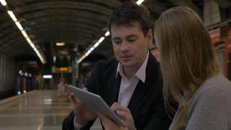 Hombre-Y-Mujer-Pasando-El-Tiempo-Con-Panel-Táctil-En-El-Metro