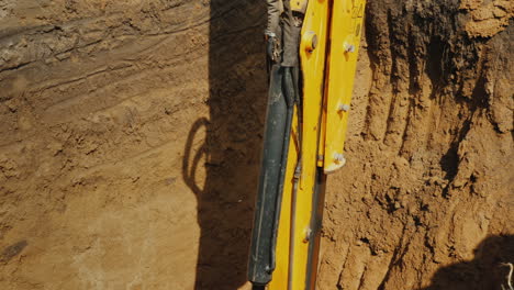 Excavator-Bucket-Extracts-Ground-From-Deep-Trench