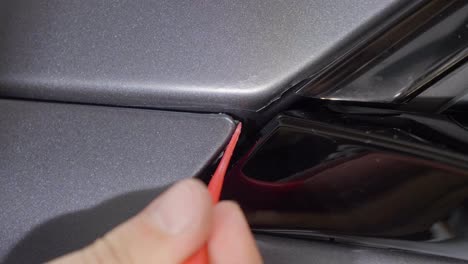 detailing car wrapping coating with small plastic tool