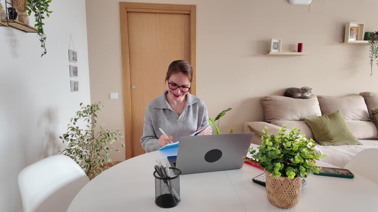 A woman working on a laptop at home