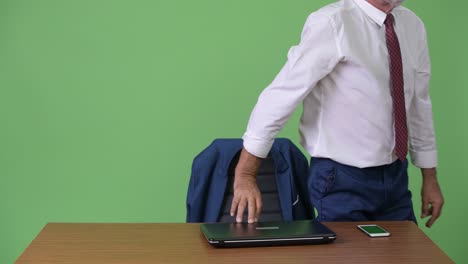 hombre de negocios barbudo y guapo contra un fondo verde.