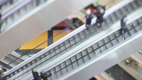 people in motion in escalators at the modern shopping mall. tilt shift lens shooting with super shallow depth of field.