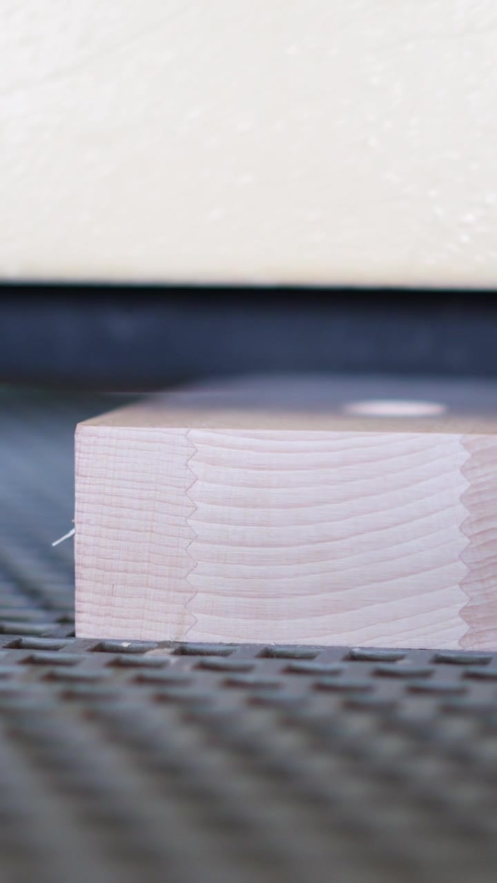 Close-up of Wooden Board Being Planed by Machine