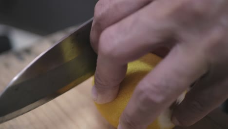 usando un cuchillo para cortar limón fresco en el