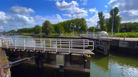 Sluice-gate-doors-closing-in-Dutch-North-Holland-blue-cloudy-flat-landscape