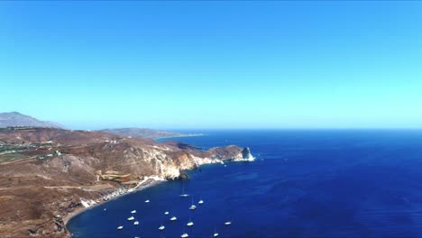 vista aérea 4k azul del mar y el cielo del acantilado con veleros atracados en santorini grecia