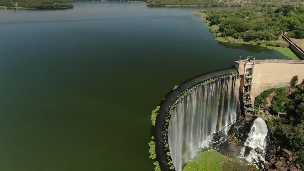imágenes aéreas de drones - agua de la pared de la presa derramándose con cascada