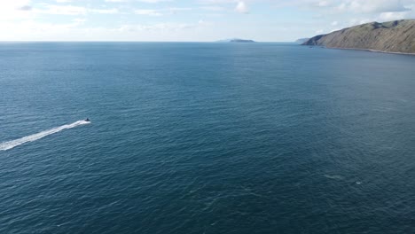 Following-a-small-boat-as-it-speeds-along-the-coastline