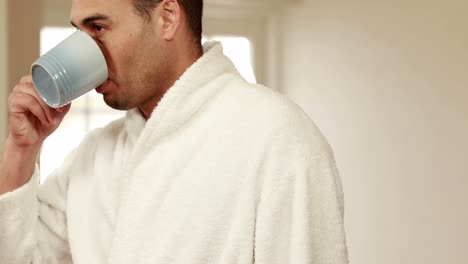 Attractive-man-wearing-bathrobe-drinking-coffee