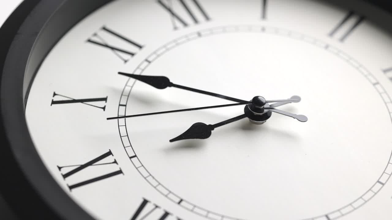 película de lapso de tiempo. gran reloj de pared blanco fija la hora para las nueve. la manilla de minutos roja sigue funcionando. números romanos