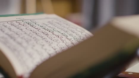 close up of open copy of the quran on stand at home 8