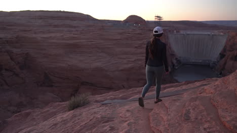 Back-View-of-Female-Walking-on-Glen-Canyon-Dam-Overlook,-Arizona-USA