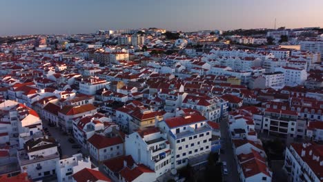 aerial orbiting shot of ericeira downtown, a portuguese surfing village during morning lights