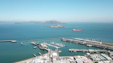 Aerial-sideways-of-Fisherman's-Wharf-bay-and-Alcatraz-island-on-a-clear-day-with-a-boat-passing