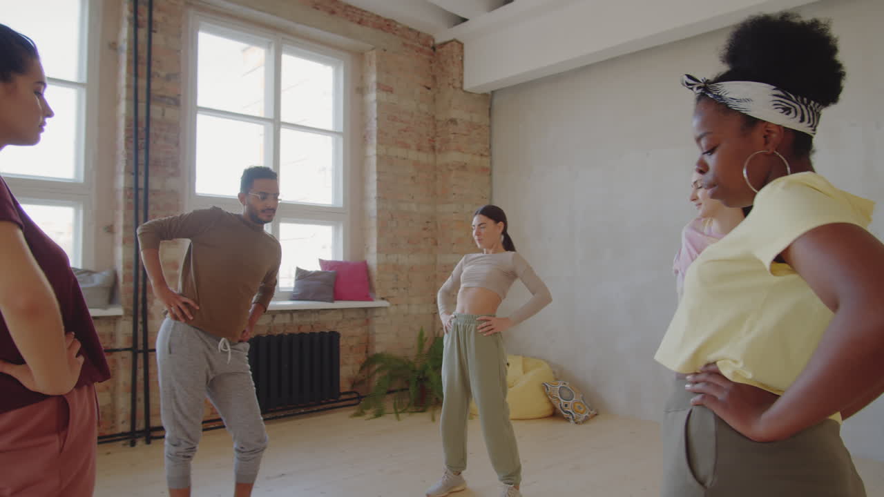 다양한 젊은이들이 춤 수업 전에 몸을 따뜻하게 하고 있습니다.