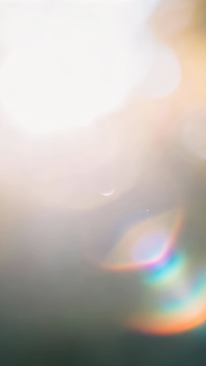 Vertical video: Pointing camera, bright glare and rainbow lens flares moving across sky from sun