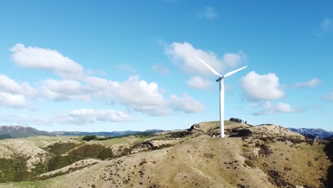 a static aerial shot of a wind turbine on a hill