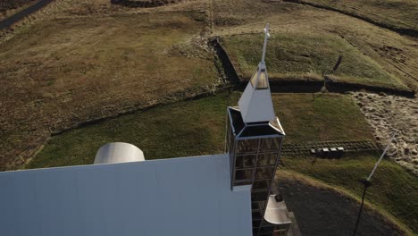 órbita aérea alrededor de la moderna iglesia luterana en el paisaje rural de islandia