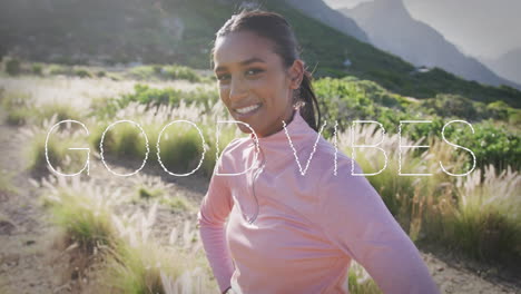 animation of the words good vibes written in white over woman exercising in mountains smiling