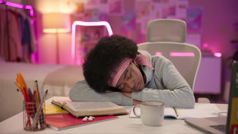 young woman sleeping at her desk after studying