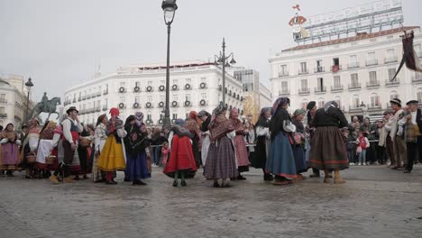 traditional dressed people on the trashumancia festival, plaza de sol in madrid, static shot, cloudy weather, copy space