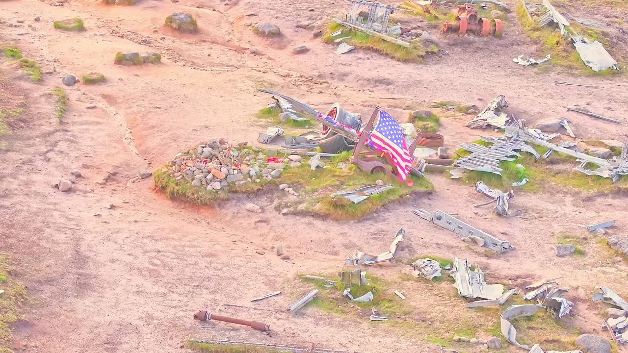 American flag waving in the wind above the memorial stone grave at the B-29 Superfortress WWII plane crash site in the Peak District, England.