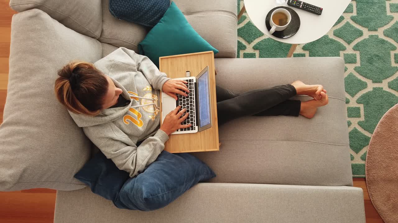 Work-from-home freelancer working on comfortable sofa with computer