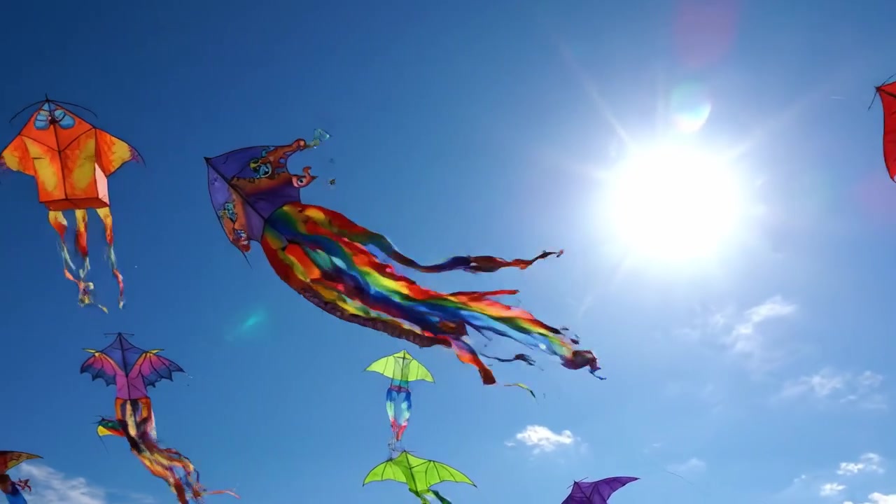 Pipas vibrantes pairam contra um céu azul claro, capturando a beleza da brincadeira ao ar livre e a alegria do voo em um dia ensolarado e brilhante.