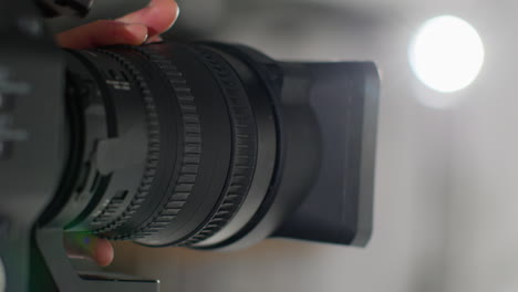 primer plano del operador de cámara de película masculino enfocando la lente en la cámara grabando una película o video en el estudio 3