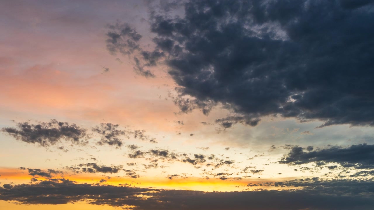 Capas de nubes resplandecientes al atardecer moviéndose a través de un cielo colorido al anochecer
