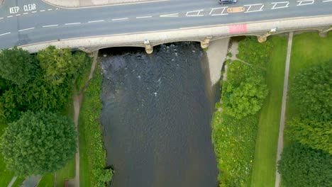 Aerial-Drone-shot-looking-vertically-down-flying-over-the-River-Tweed-towards-the-Tweed-Bridge-in-the-town-of-Peebles-in-the-Scottish-Borders