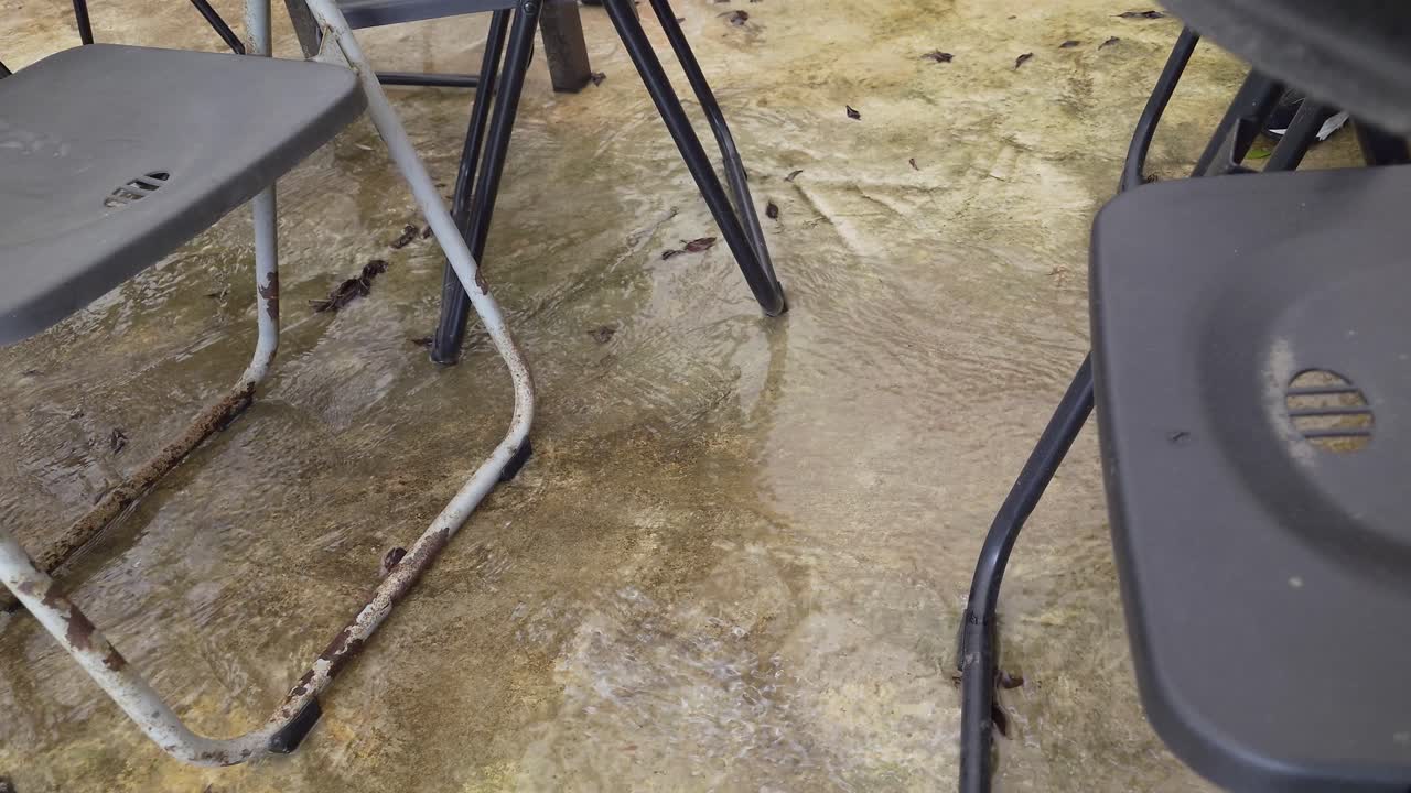 toma de primer plano del agua que fluye bajo las sillas durante la temporada de lluvias