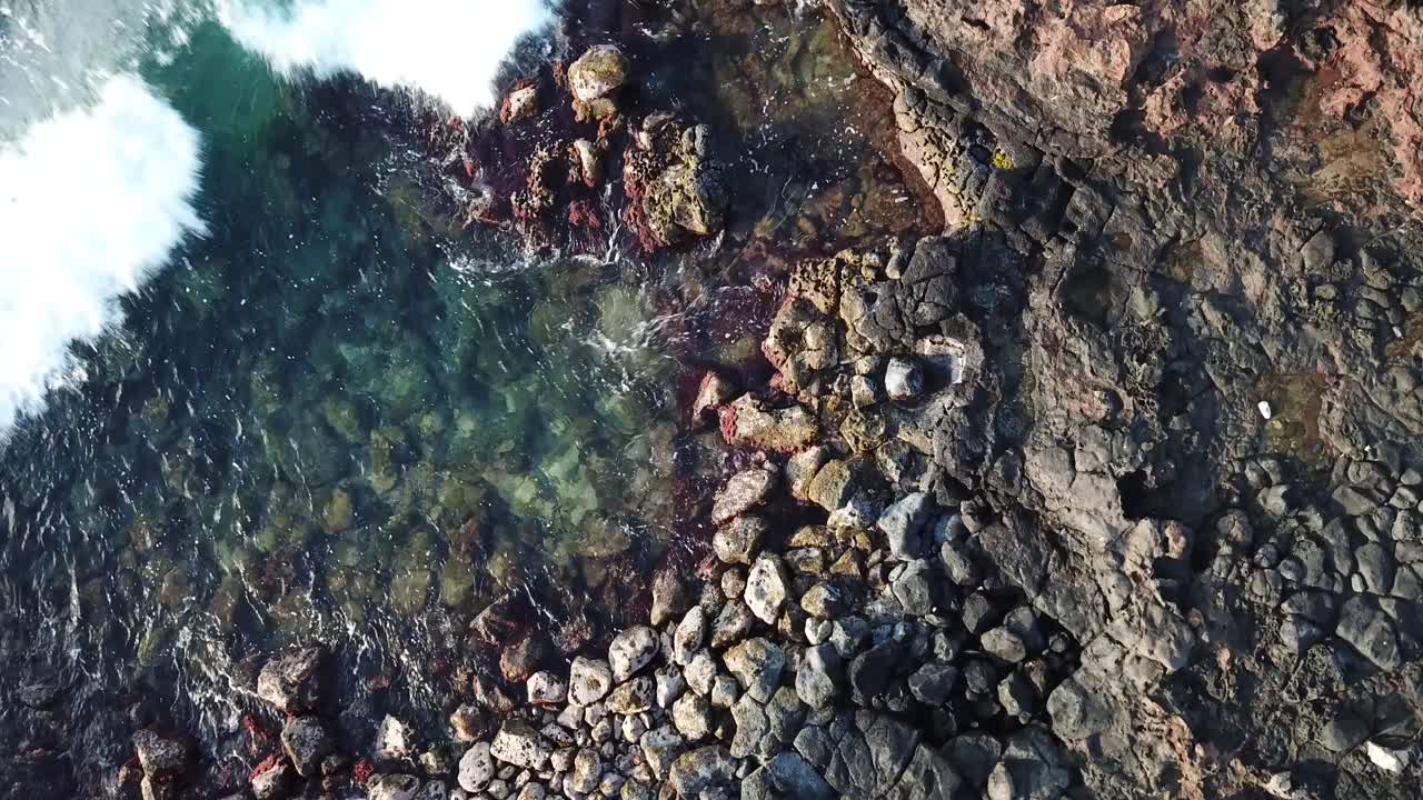 Ripresa dall'alto di onde che colpiscono e coprono le rocce alle Hawaii.