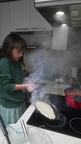 a young girl making pancakes