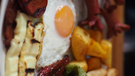 a hearty breakfast platter with fried eggs, sausages, and vegetables