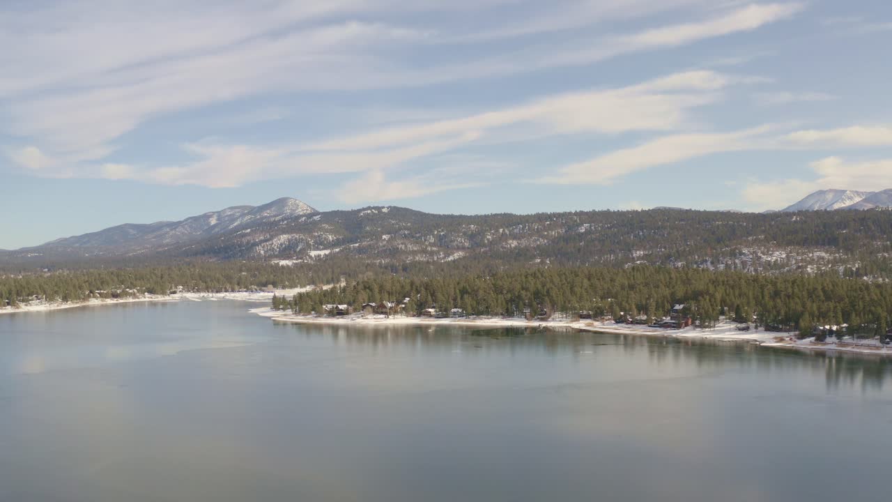 Big Bear icy lake with snow and trees via drone
