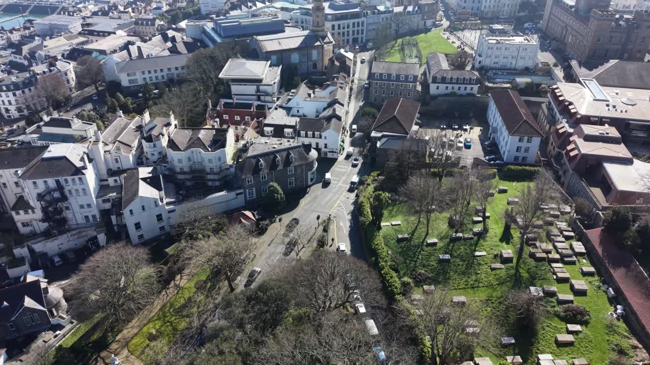 St Peter Port Guernsey, flygfilm som följer St Julian's Avenue till St James Assembly halls, med utsikt över staden och ut mot havet med en dimmig Havelet Bay i fjärran under den gyllene timmen