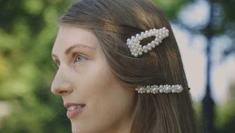 closeup image of a beautiful caucasian woman with white pearl beaded hair clips - rack focus slow motion