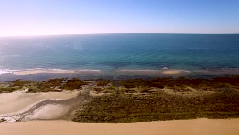 Vuelo-Aéreo-Desde-Una-Playa-De-Arena-Sobre-La-Playa-Intermareal-Hasta-Las-Olas-Del-Océano,-Golfo-De-California,-México