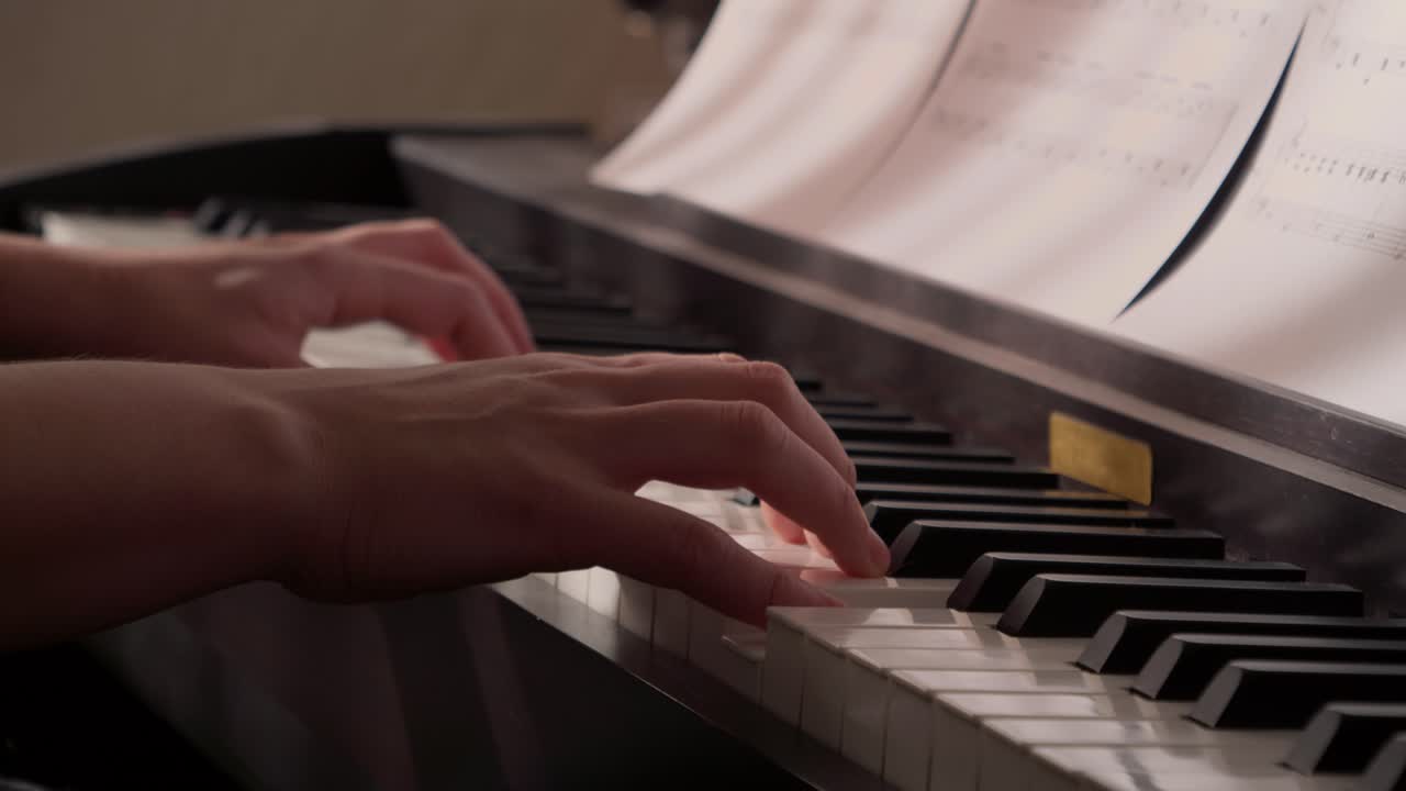 Close-Up of Hands Playing Piano with Sheet Music