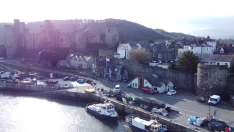 idyllic conwy castle and harbour fishing town boats on coastal waterfront aerial