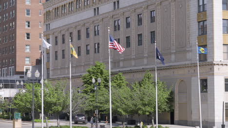 waving flags next to a brick building in downtown grand rapids, michigan