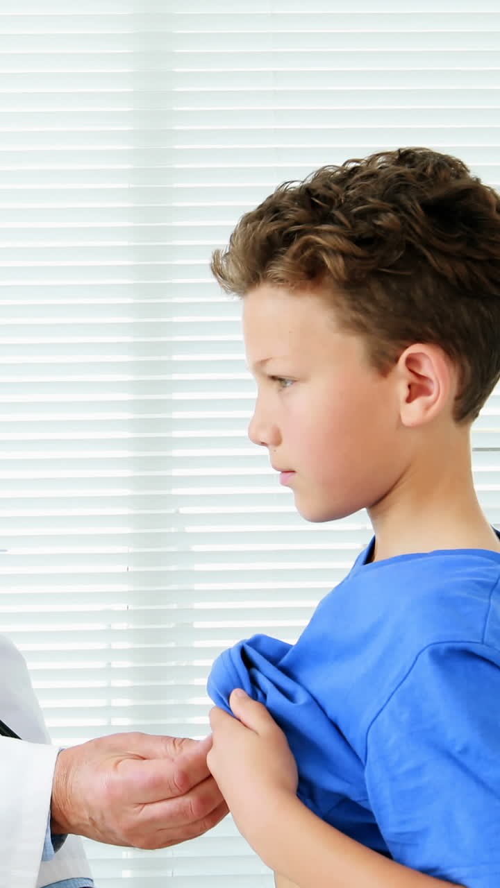 남자 의사 가 소년 을 검사 하고 있다