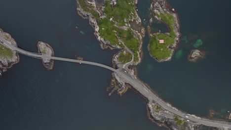 vista aérea sobre los coches que conducen a lo largo de la carretera del puente atlántico en noruega en un día nublado